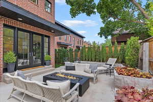 Fenced backyard with french doors, a patio area, and an outdoor living space with a fire pit