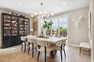 Dining space with light wood-style flooring and hanging lights