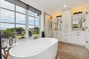 Bathroom featuring vanity, a freestanding bath, light wood-style flooring, and recessed lighting