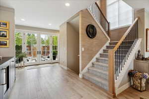 Staircase with french doors and wood finished floors