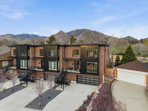 View of front of house featuring board and batten siding, a mountain view, an outdoor structure, and a garage