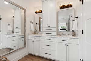 Full bathroom featuring double vanity and light wood-type flooring