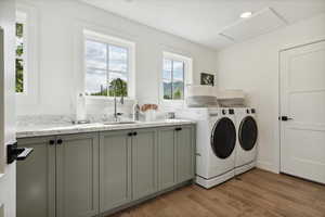 Laundry room with dark wood finished floors, washer and dryer, recessed lighting, and cabinet space