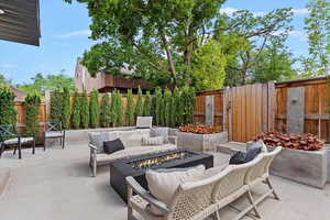 Fenced backyard with a patio area and an outdoor living space with a fire pit