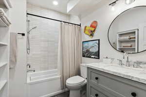 Bathroom with vanity, shower / bath combo with shower curtain, and recessed lighting