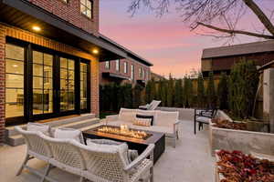 Patio terrace at dusk featuring french doors, a patio, and an outdoor fire pit