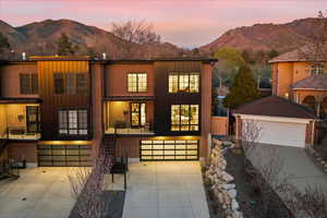 View of front of property with board and batten siding, a mountain view, concrete driveway, an attached garage, and brick siding