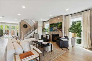 Living room with hardwood / wood-style flooring, a tile fireplace, french doors, and recessed lighting