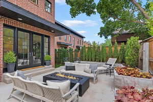 Fenced backyard with french doors, a patio, and an outdoor living space with a fire pit