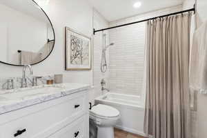 Full bathroom featuring vanity, shower / bath combo, and recessed lighting
