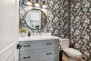 Bathroom featuring vanity and wallpapered walls