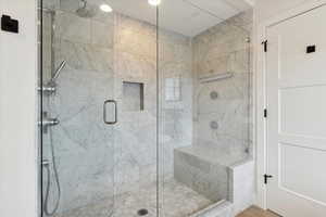 Full bath with a marble finish shower