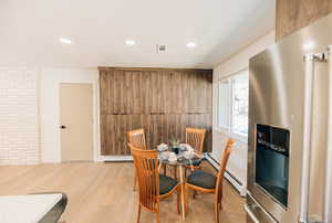 Dining area with a baseboard radiator, recessed lighting, and light wood-type flooring