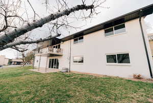 Back of property with brick siding, a patio area, and a yard