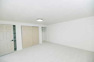 Unfurnished bedroom with light carpet and two closets