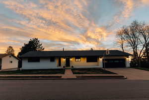 Single story home with a garage, brick siding, concrete driveway, a chimney, and a porch