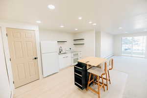 Kitchen featuring white appliances, open shelves, light countertops, recessed lighting, and white cabinets