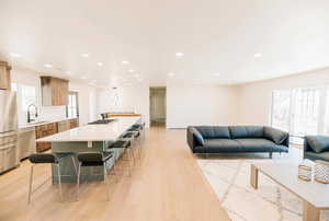 Living area with light wood-style flooring and recessed lighting