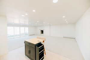 Kitchen with light colored carpet, recessed lighting, a fireplace, open floor plan, and baseboard heating