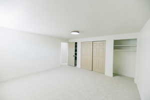 Unfurnished bedroom with light colored carpet and multiple closets