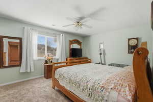 Bedroom with light colored carpet and a ceiling fan