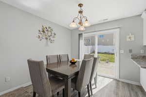 Dining room with light wood-style floors and a chandelier