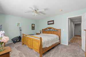 Bedroom with light carpet and a ceiling fan