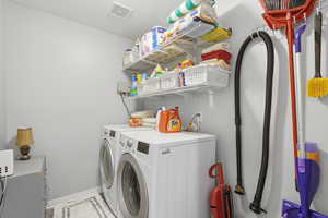 Laundry area with independent washer and dryer and a textured ceiling