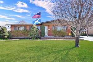 View of front facade with brick siding and a front yard