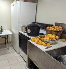 Kitchen featuring white appliances and light tile patterned flooring