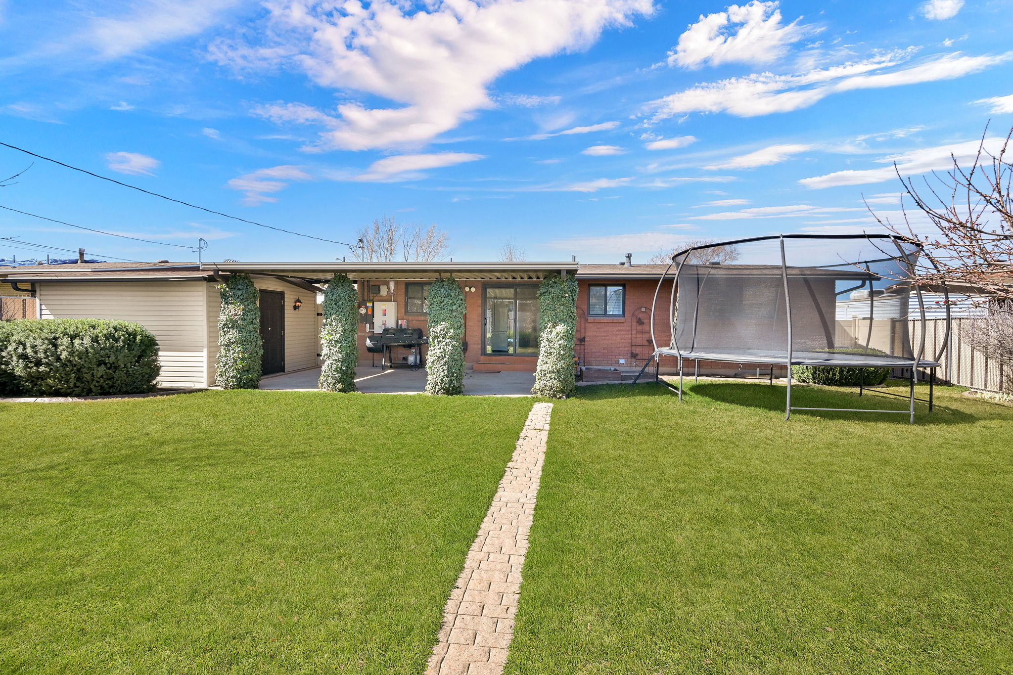 View of front of house featuring a trampoline and a patio