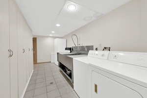 Laundry room featuring separate washer and dryer, light tile patterned floors, canning station, and recessed lighting