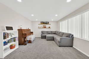 Living area with light carpet and recessed lighting