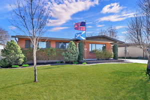 View of front facade featuring brick siding and a front lawn
