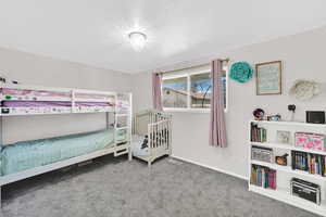 Bedroom featuring light colored carpet and a textured ceiling