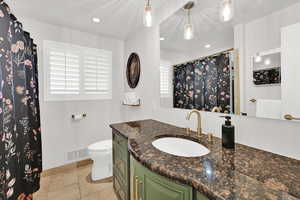 Bathroom featuring vanity, a shower with curtain, light tile patterned floors, and recessed lighting
