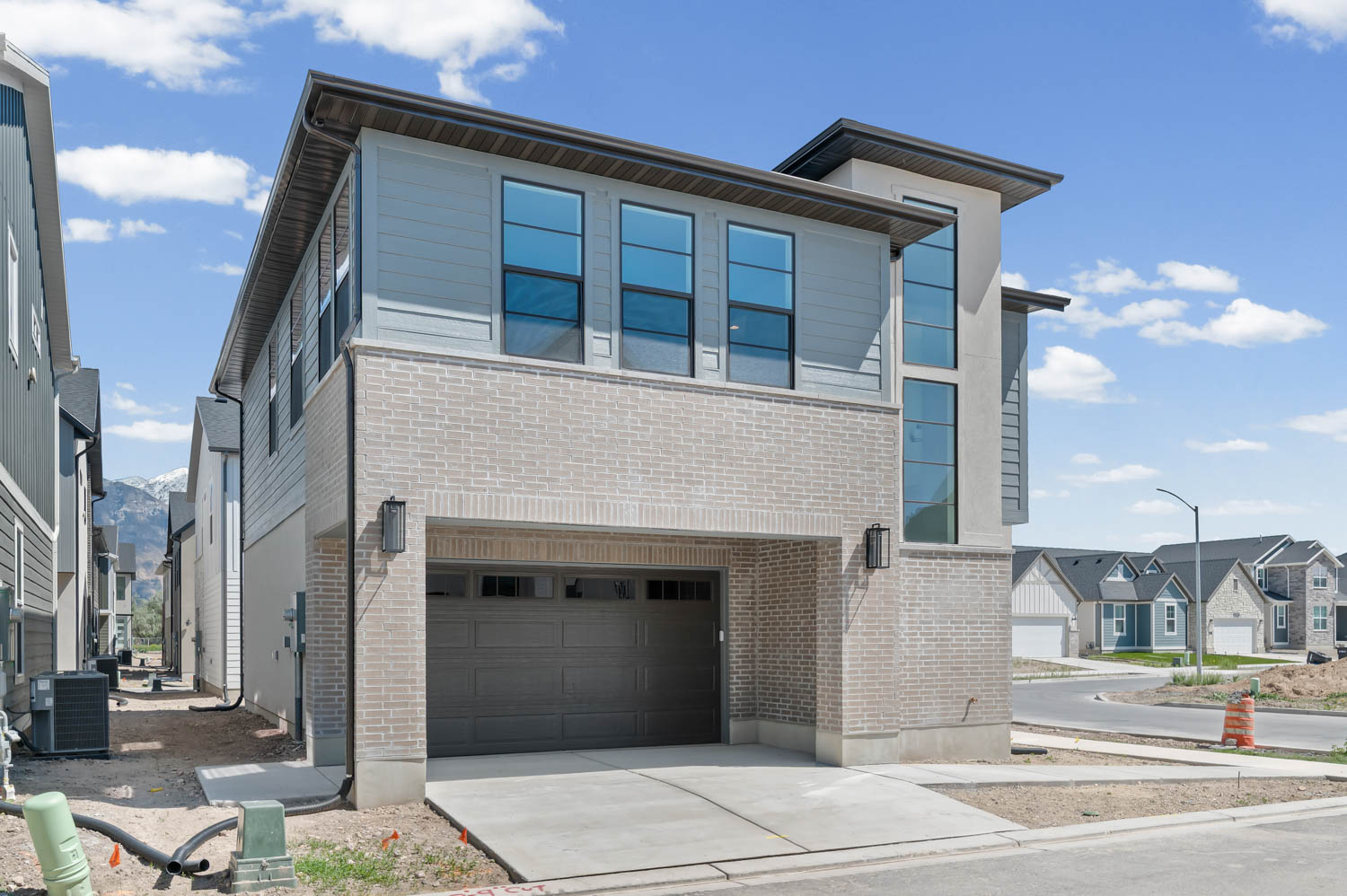 Contemporary home with a garage, brick siding, and concrete driveway