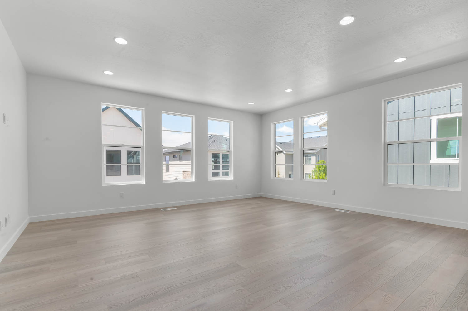 Unfurnished room with light wood finished floors, recessed lighting, and healthy amount of natural light