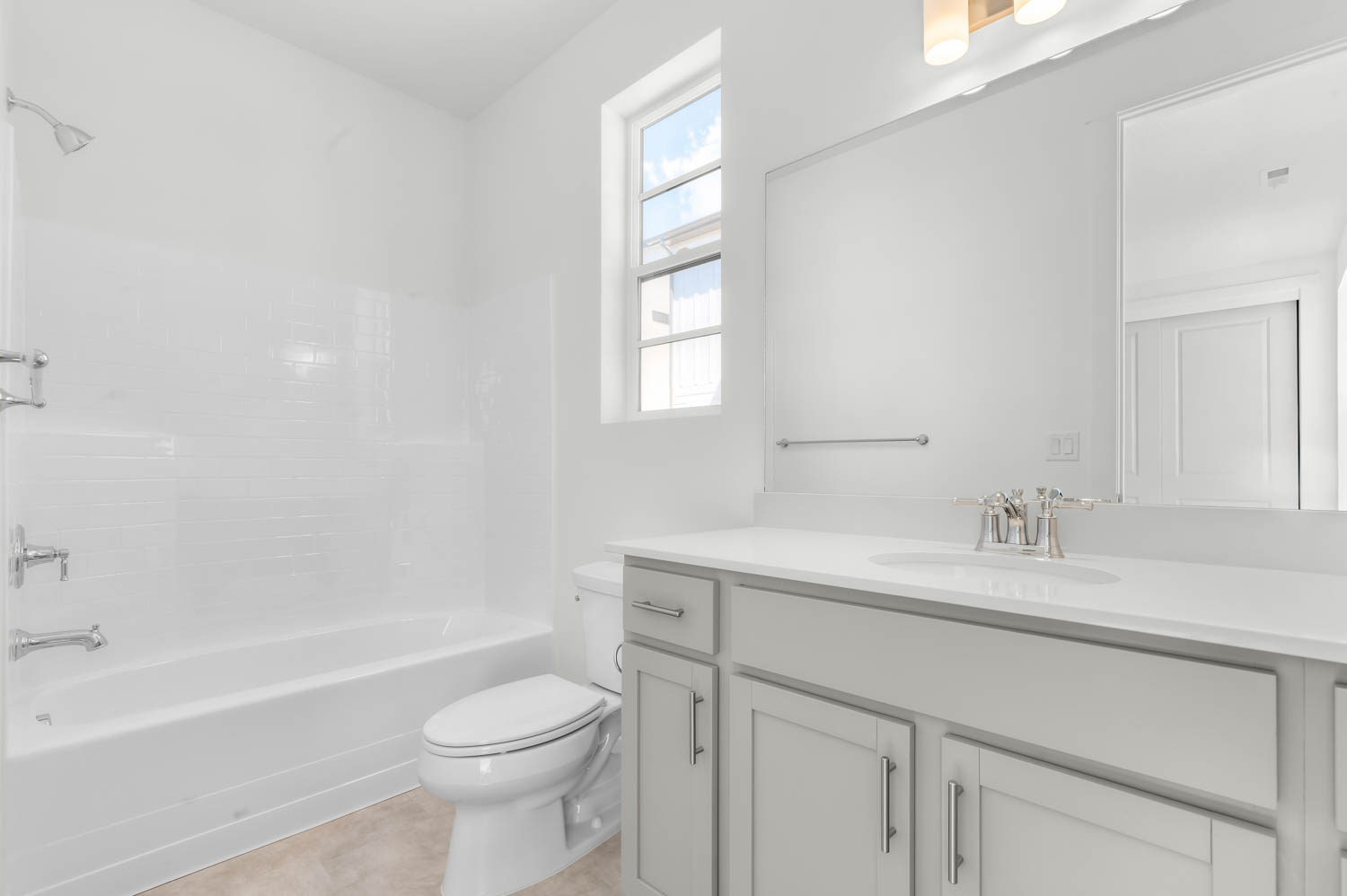 Bathroom featuring vanity, shower / bathtub combination, and light tile patterned flooring