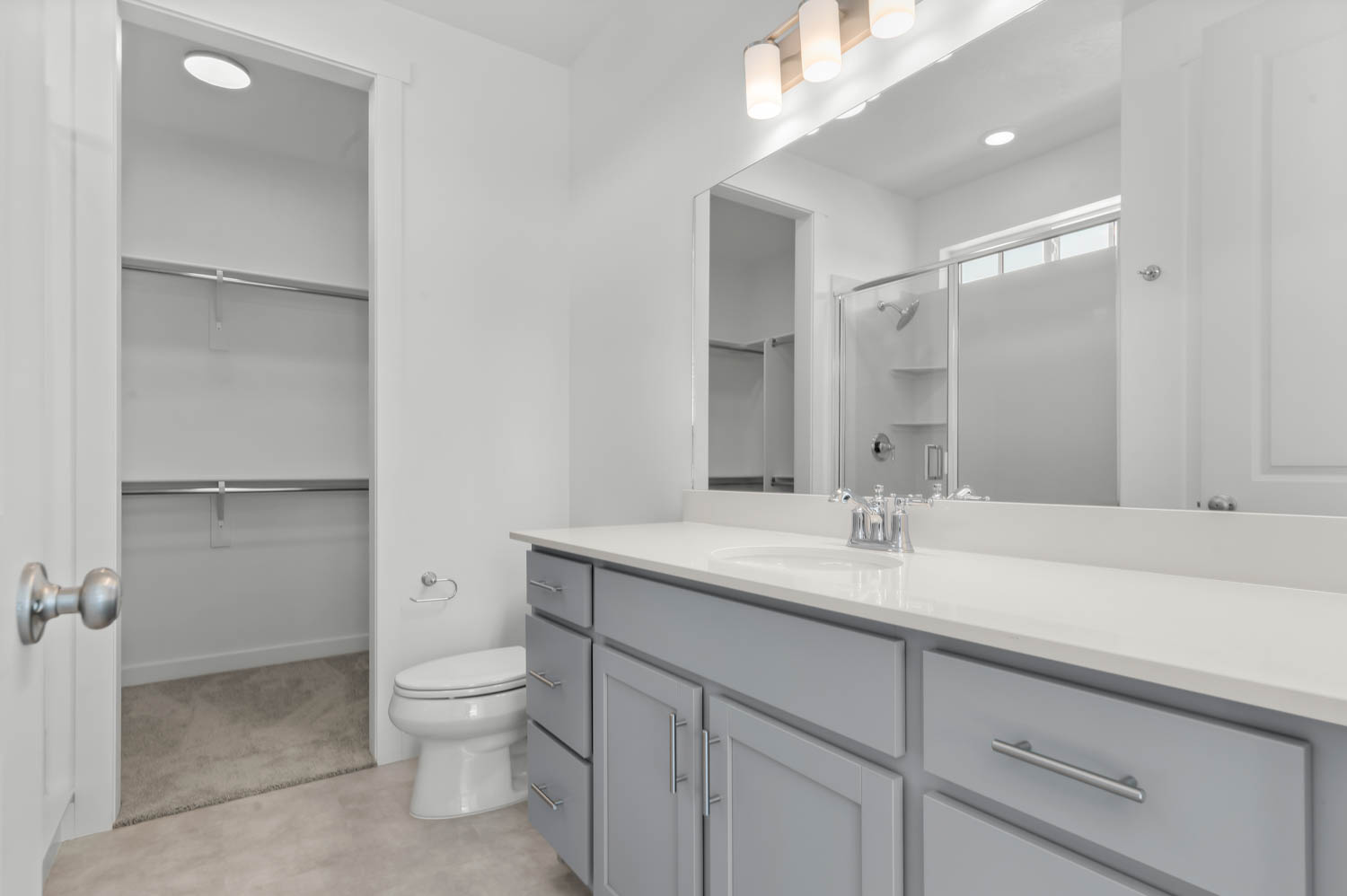 Full bath with a spacious closet, a stall shower, vanity, and recessed lighting