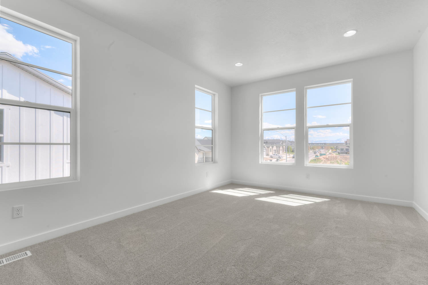 Carpeted empty room with baseboards and recessed lighting