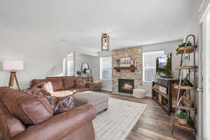 Living area featuring a stone fireplace and wood finished floors