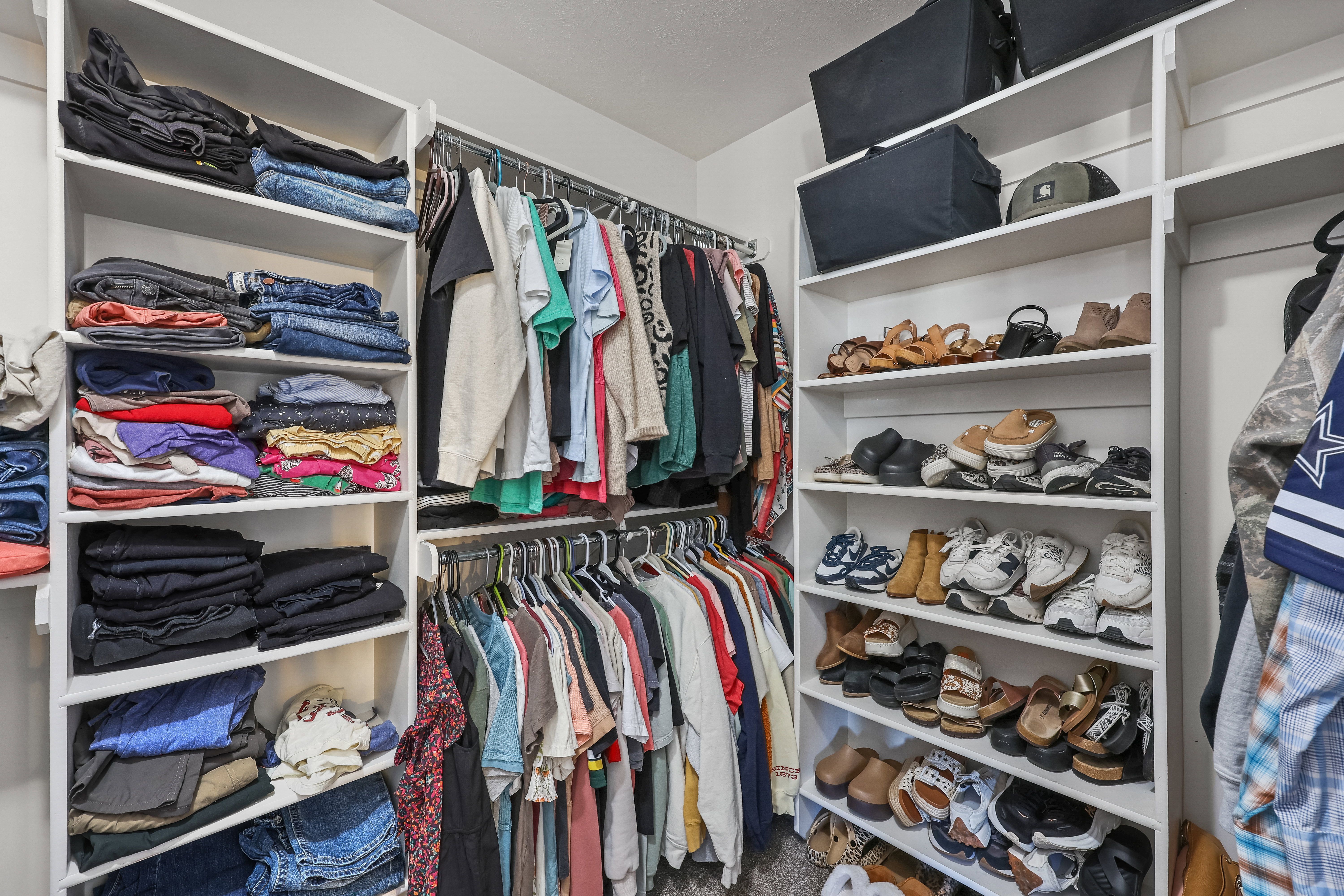 Walk in closet with dark colored carpet