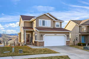 Traditional home featuring a front lawn, stucco siding, concrete driveway, an attached garage, and a mountain view