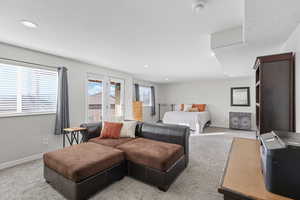 Carpeted bedroom with a textured ceiling and recessed lighting