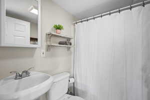 Bathroom featuring toilet and a shower with curtain