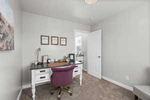 Office featuring dark colored carpet and baseboards