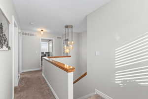 Corridor with an upstairs landing and carpet flooring