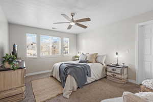 Carpeted bedroom featuring baseboards and a ceiling fan
