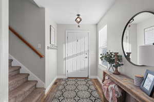Foyer entrance with stairway and dark wood-type flooring